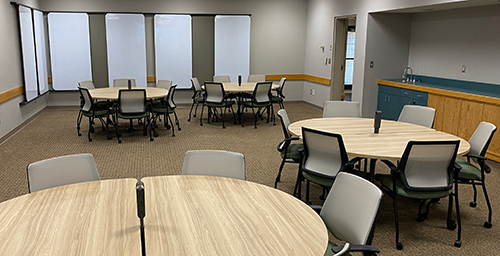 view of training room with round tables and white boards